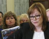 Mary Theresa Ruddy (L), whose daughter was killed in 2010 when she lost control of her 2005 Chevrolet Cobalt, holds a picture of the vehicle, as General Motors CEO Mary Barra testifies before the Senate Commerce and Transportation Consumer Protection, Product Safety and Insurance subcommittee in Washington April 2, 2014. REUTERS/Gary Cameron