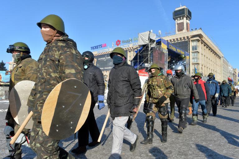 Ukrainian opposition protesters holding makeshift shields march to guard Independence Square in central Kiev, on January 30, 2014