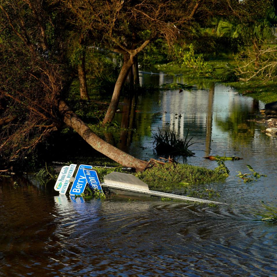 A fallen road sign and fallen trees are seen near flooded river aftermath of hurricane in Punta Gorda district of Florida on September 29, 2022.  / Credit: Ben Hendren/Anadolu Agency via Getty Images