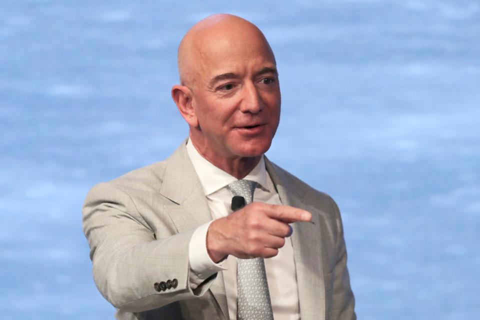 Jeff Bezos points and looks off camera onstage