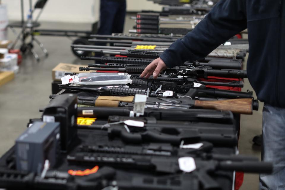 Semi-Automatic weapons, rifles, etc lay across a table for people to look at, during the Novi Gun and Knife Show at Suburban Collection Showplace in Novi, Mich. on Feb. 24, 2018.