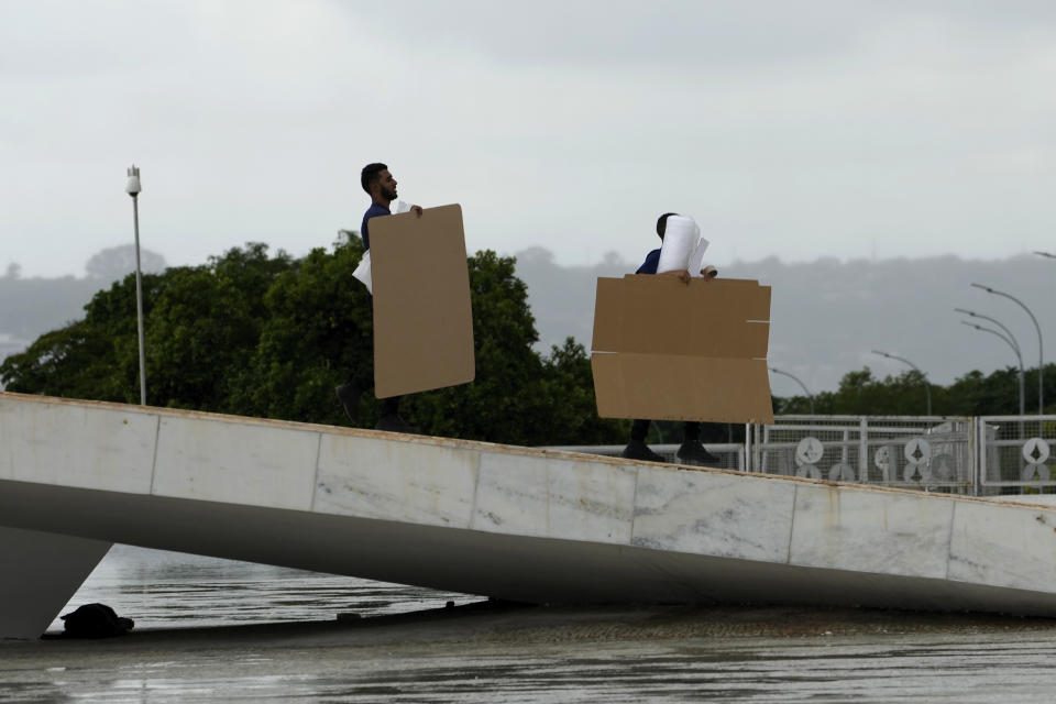 Workers carry moving materials at the presidential palace in Brasilia, Brazil, Friday, Dec. 16, 2022. President-elect Luiz Inácio Lula da Silva will be sworn-in on Jan. 1, 2023. (AP Photo/Eraldo Peres)