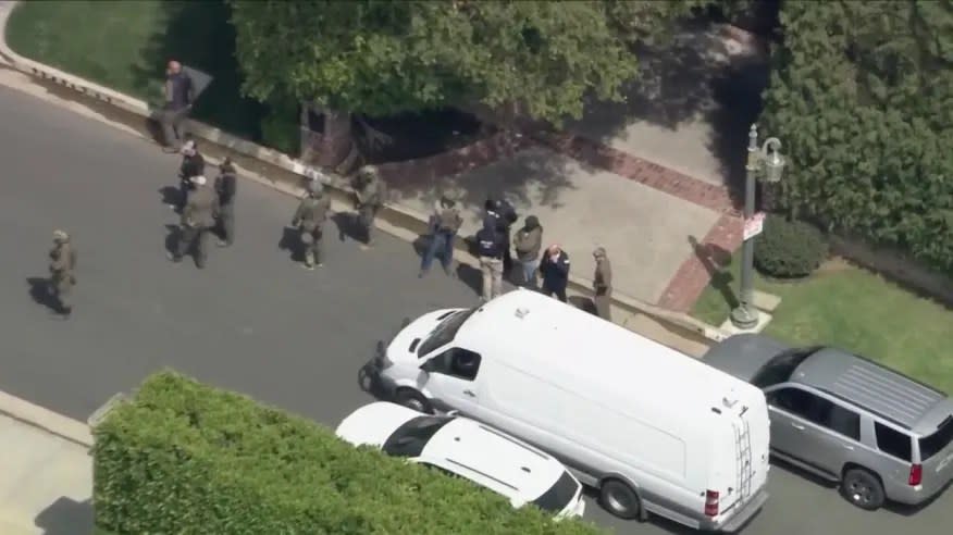 Homeland Security agents surround a Holmby Hills mansion associated with rapper Sean “Diddy” Combs on Monday, March 25. (KTLA)