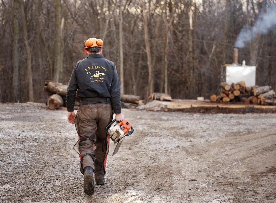 Darwin Woods carries his chainsaw to cut up wood for his wood burning stove that he uses to heat his workshop Friday, Feb. 21, 2014, at his home near Clark, Mo. Proposed regulations from the U.S. Environmental Protection Agency would significantly reduce the amount of particle pollution allowed from the smokestacks of new residential wood-powered heaters. The proposed regulations have sparked a backlash from some rural residents, lawmakers and manufacturers who fear it could close the damper on one of the oldest ways of warming homes on cold winter days. (AP Photo/L.G. Patterson)