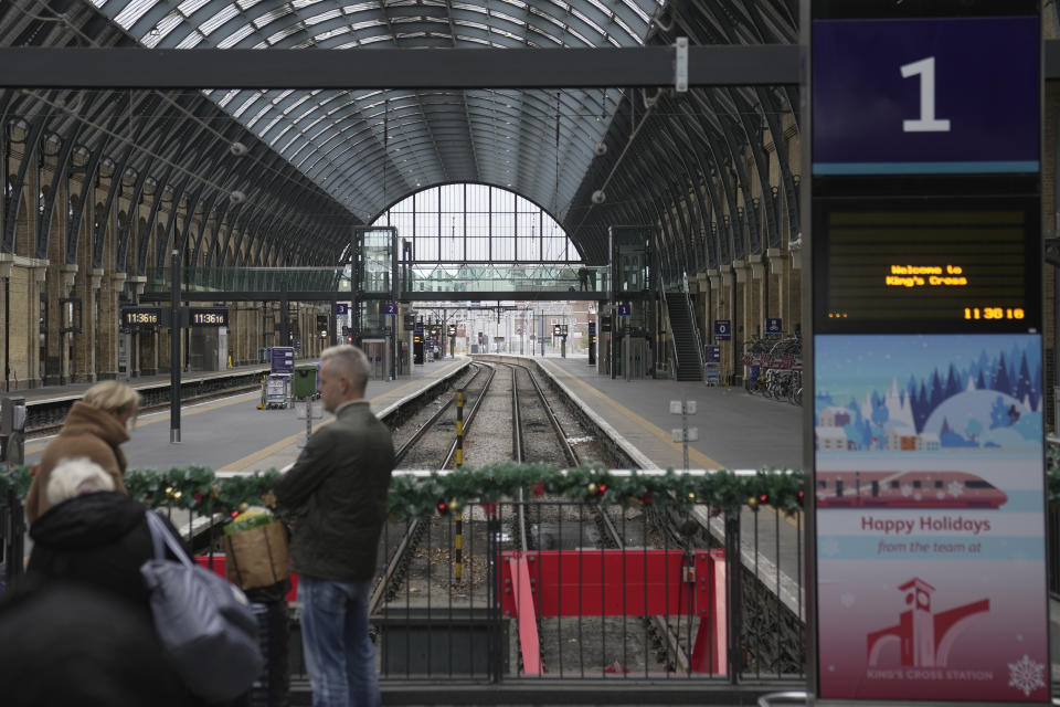 Travellers wait for a train at platform 1 in King's Cross station in London, Thursday, Dec. 21, 2023. Rail travellers over the Christmas holiday season will have to contend with disruptions to services due to engineering work and bad weather. (AP Photo/Kin Cheung)