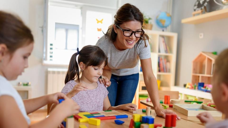 Children playing with blocks and childcare worker