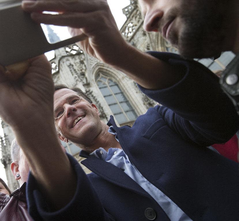 Dutch Prime Minister Mark Rutte takes a selfie with a well-wisher during a campaign stop in Breda, Netherlands, Saturday, March 11, 2017. (AP Photo/Peter Dejong)
