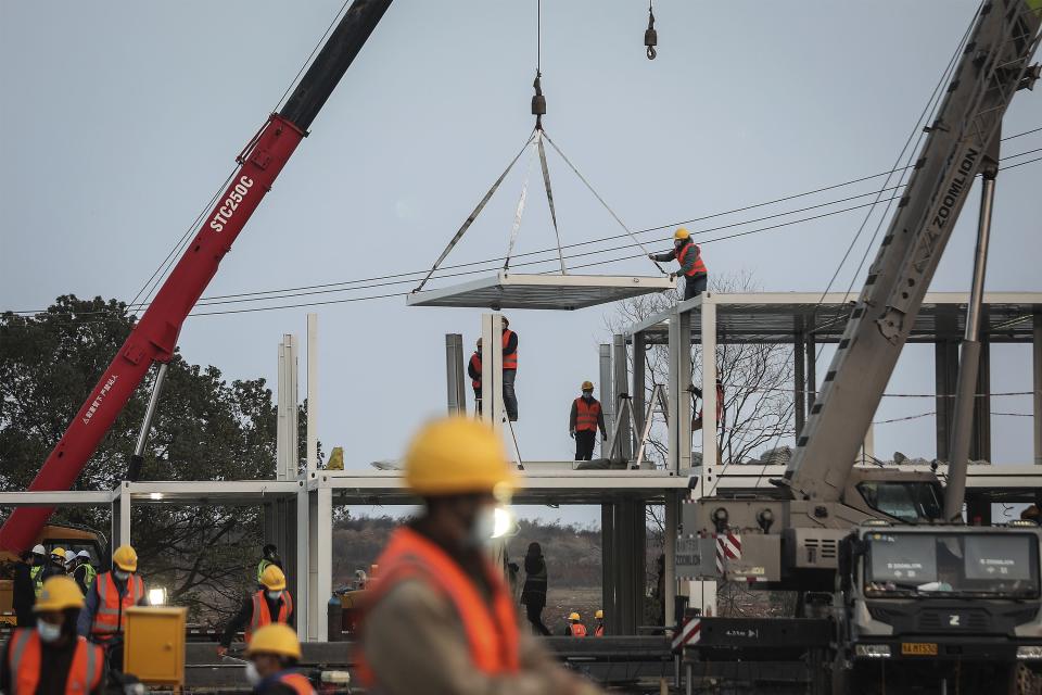 Construction workers guide a crane on Jan. 28.