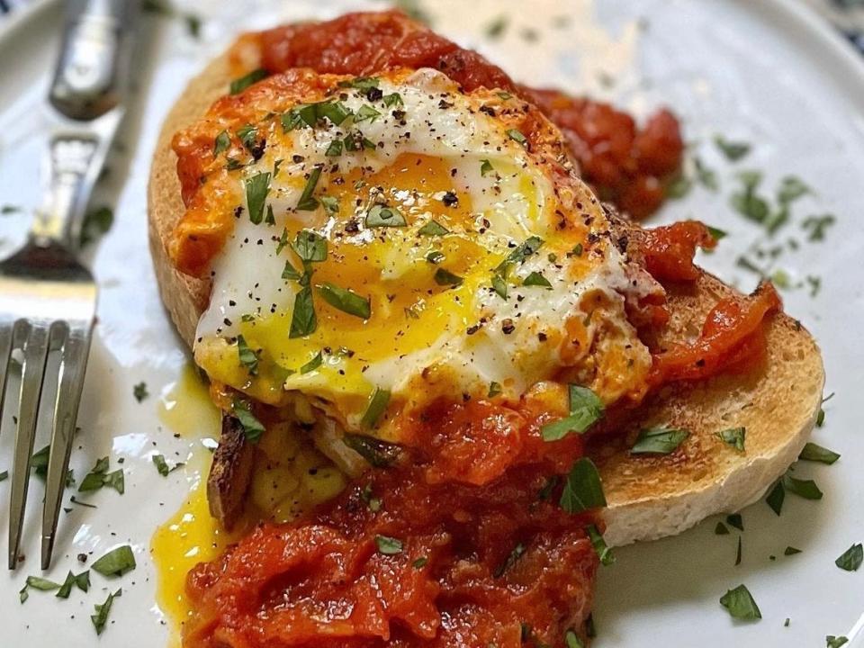 Egg with tomatoes and toast on plate