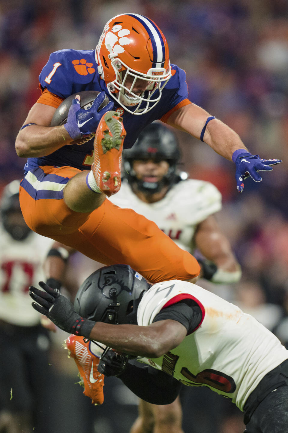 Clemson running back Will Shipley (1) hurdles over Louisville safety M.J. Griffin (26) on his way to a touchdown in the second half of an NCAA college football game, Saturday, Nov. 12, 2022, in Clemson, S.C. (AP Photo/Jacob Kupferman)