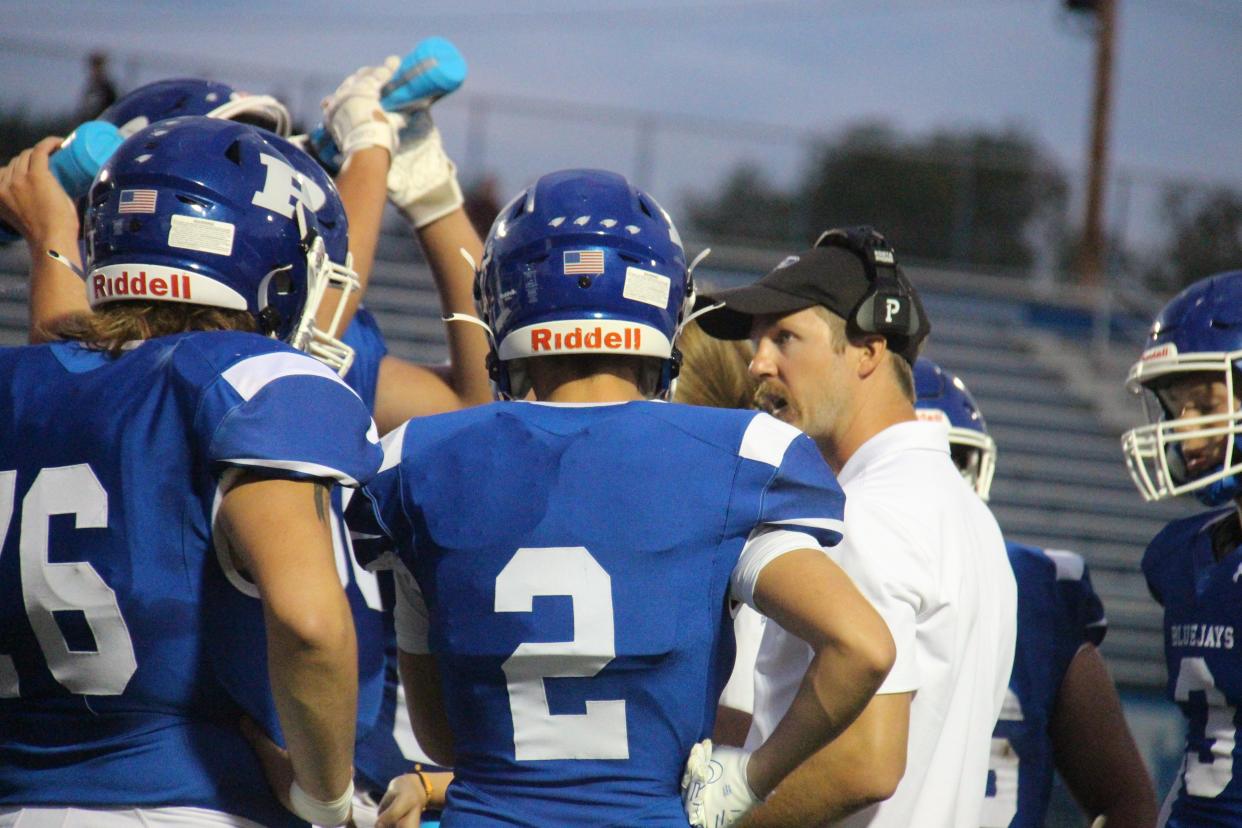 Perry coach Bryce Pierce talks to players during a timeout on Aug. 19 in Perry.