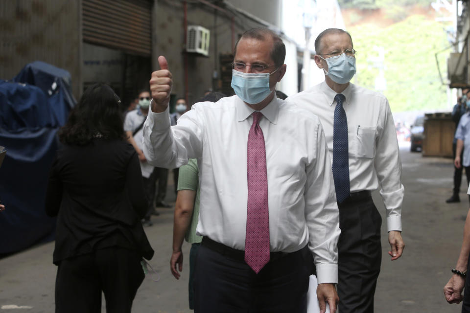 U.S. Health and Human Services Secretary Alex Azar thumbs up as he visits a mask factory with Director of the American Institute in Taiwan (AIT) William Brent Christensen, right, in New Taipei City, Taiwan Wednesday, Aug. 12, 2020. Wednesday is the last day of Azar's schedule during the highest-level visit by an American Cabinet official since the break in formal diplomatic ties between Washington and Taipei in 1979. (AP Photo/Chiang Ying-ying)