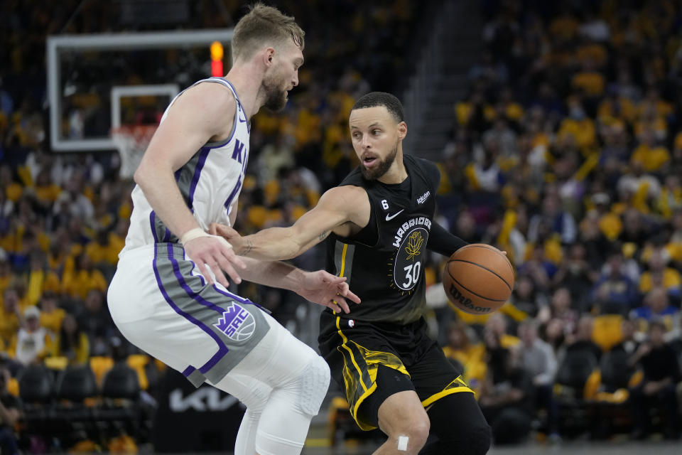 Golden State Warriors guard Stephen Curry (30) drives to the basket against Sacramento Kings forward Domantas Sabonis during Game 3 in the first round of the NBA basketball playoffs in San Francisco, Thursday, April 20, 2023. (AP Photo/Jeff Chiu)