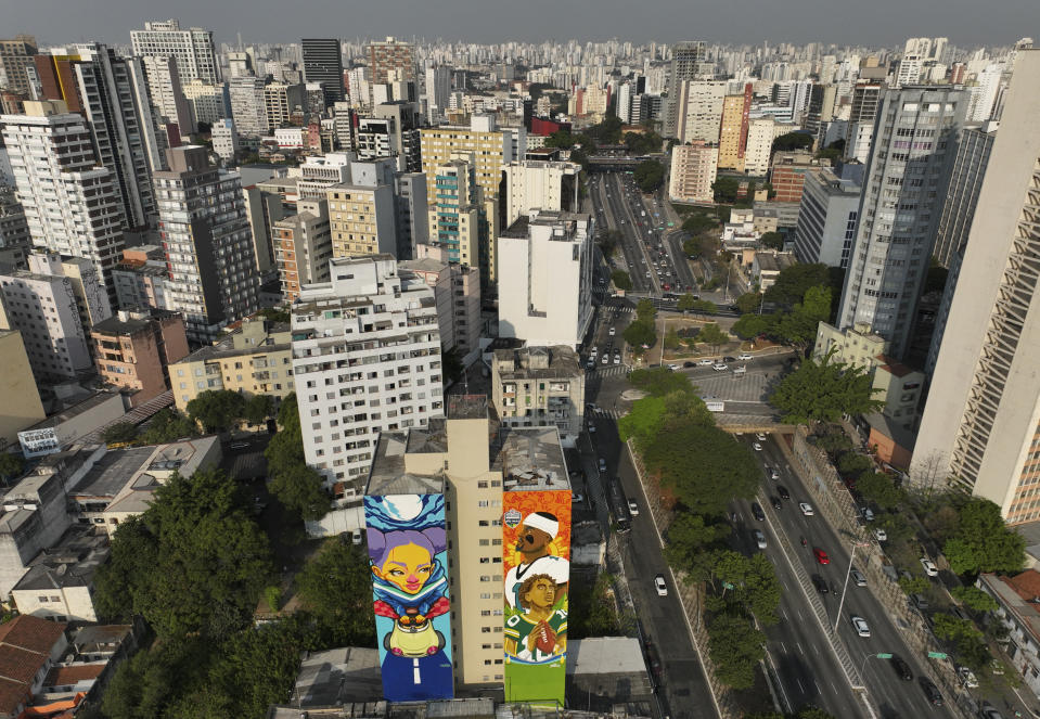 A mural created by artist Crica, center right, featuring Philadelphia Eagles quarterback Jalen Hurts and Green Bay Packers quarterback Jordan Love adorns an apartment building in downtown Sao Paulo, Wednesday, Sept. 4, 2024. (AP Photo/Andre Penner)