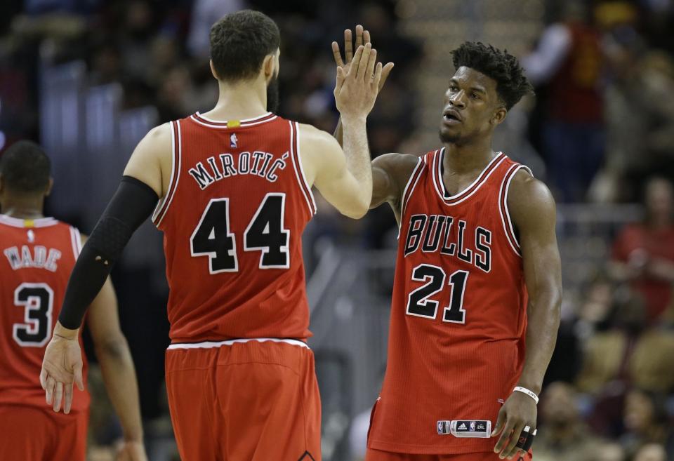 Chicago Bulls' Nikola Mirotic (44) and Jimmy Butler (21) celebrate late in the second half of an NBA basketball game against the Cleveland Cavaliers, Saturday, Feb. 25, 2017, in Cleveland. (AP Photo/Tony Dejak)