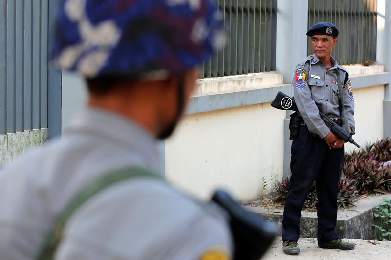 Police stand guard while Rohingya Muslims appear in court to face charges of travelling illegally, in Pathein