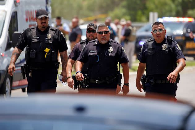 Police walk near Robb Elementary School following a shooting that killed 19 children and two teachers, May 24, 2022, in Uvalde, Texas.