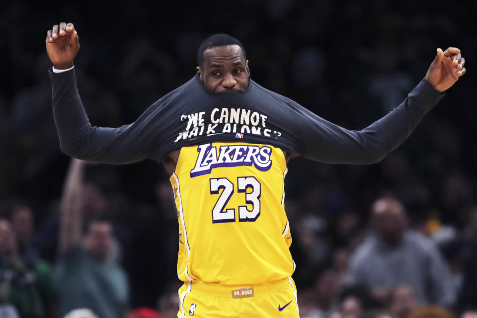 Los Angeles Lakers forward LeBron James puts on a warm-up shirt as he goes to the bench during the first half of an NBA basketball game against the Boston Celtics in Boston, Monday, Jan. 20, 2020. (AP Photo/Charles Krupa)