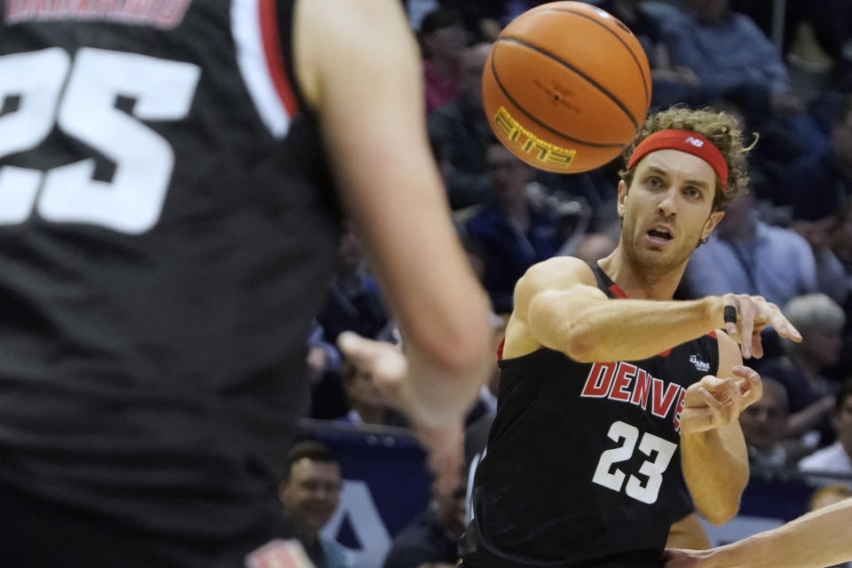 Denver guard Jaxon Brenchley (23) passes to his teammate Touko Tainamo (25) during the first half of an NCAA college basketball game against BYU, Wednesday, Dec. 13, 2023, in Provo, Utah. (AP Photo/George Frey)