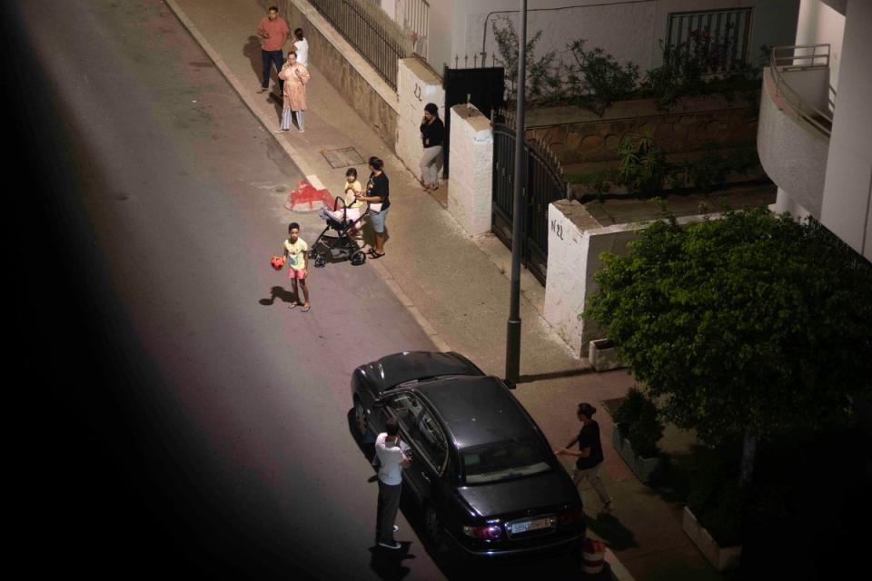 People take shelter outside their homes in the capital Rabat (AP)