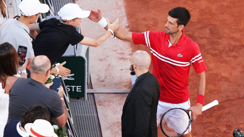 Novak Djokovic, pictured here celebrating with the young fan after winning the French Open.