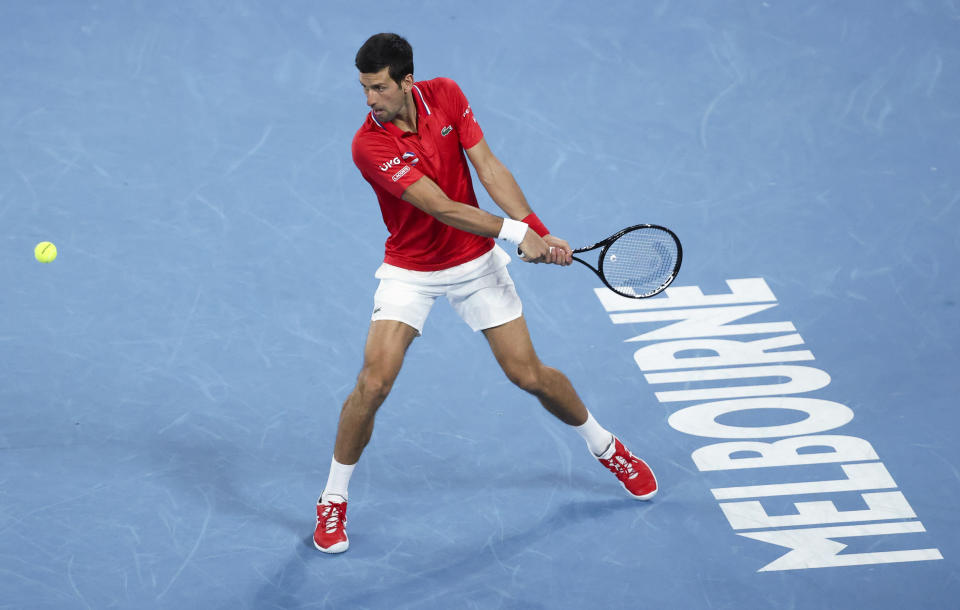 Serbia's Novak Djokovic makes a backhand return to Germany's Alexander Zverev during their ATP Cup match in Melbourne, Australia, Friday, Feb. 5, 2021.(AP Photo/Hamish Blair)
