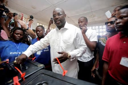 FILE PHOTO: George Weah, former soccer player and presidential candidate of Congress for Democratic Change (CDC), votes at a polling station in Monrovia, Liberia, October 10, 2017. REUTERS/Thierry Gouegnon/File Photo