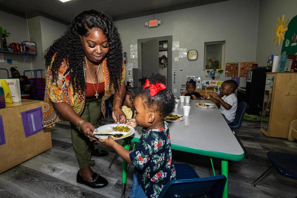 Angela James, the operator of Sunrise Early Learning and Development Center, helps Journi Qualls, 2, put away her plate during lunch break at the school in Fort Worth on Thursday, Oct. 26, 2023.