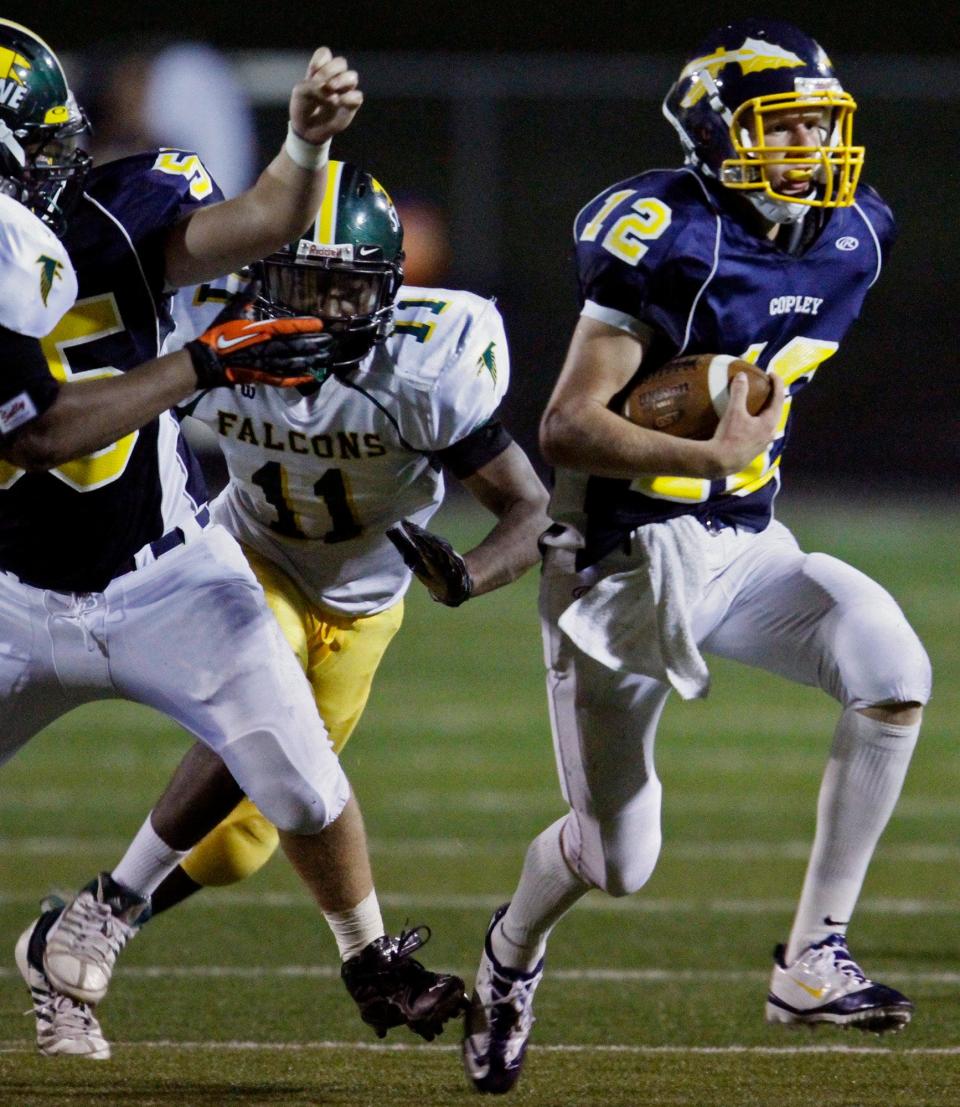 Copley quarterback John Kromalic (right) breaks away from Firestone linebacker Chris Strong at Copley High School on Aug. 31, 2012. Kromalic is set to become Copley's new head coach.