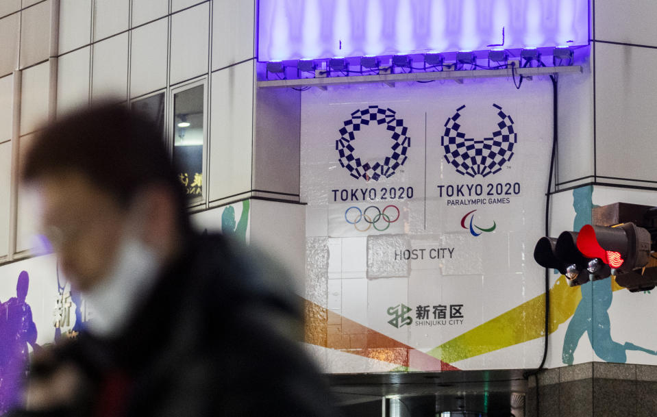 A man walks past Tokyo's promotional banners for its rescheduled Olympic games to be held in the summer 2021, in Tokyo on Thursday, Jan. 28, 2021. (AP Photo/Hiro Komae)