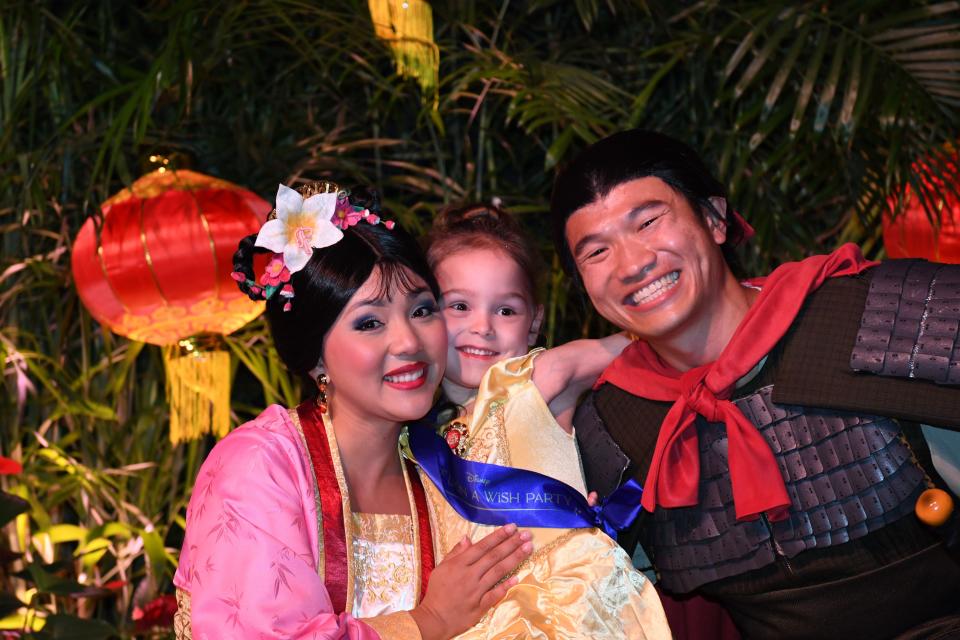 A Wish kid embraces Mulan and Li Shang at the Once Upon a Wish Party.