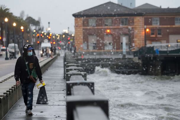 PHOTO: A person walks along The Embarcadero in San Francisco, Jan. 4, 2023. Another winter storm is expected to move into California walloping the northern part of the state with more rain and snow. (Godofredo A. Vaisquez/AP)