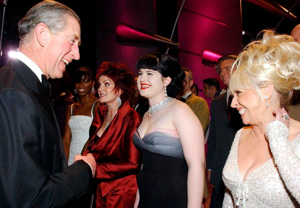 FILE - In this Dec. 14, 2004, file photo, Britain's Prince Charles shares a joke with actress Barbara Windsor, right, and Kelly Osbourne, center, as Kelly's mother Sharon Osbourne looks on, backstage during filming of the Royal Variety Performance at the London Coliseum, in central London. (AP Photo/Chris Young/Pool, File)