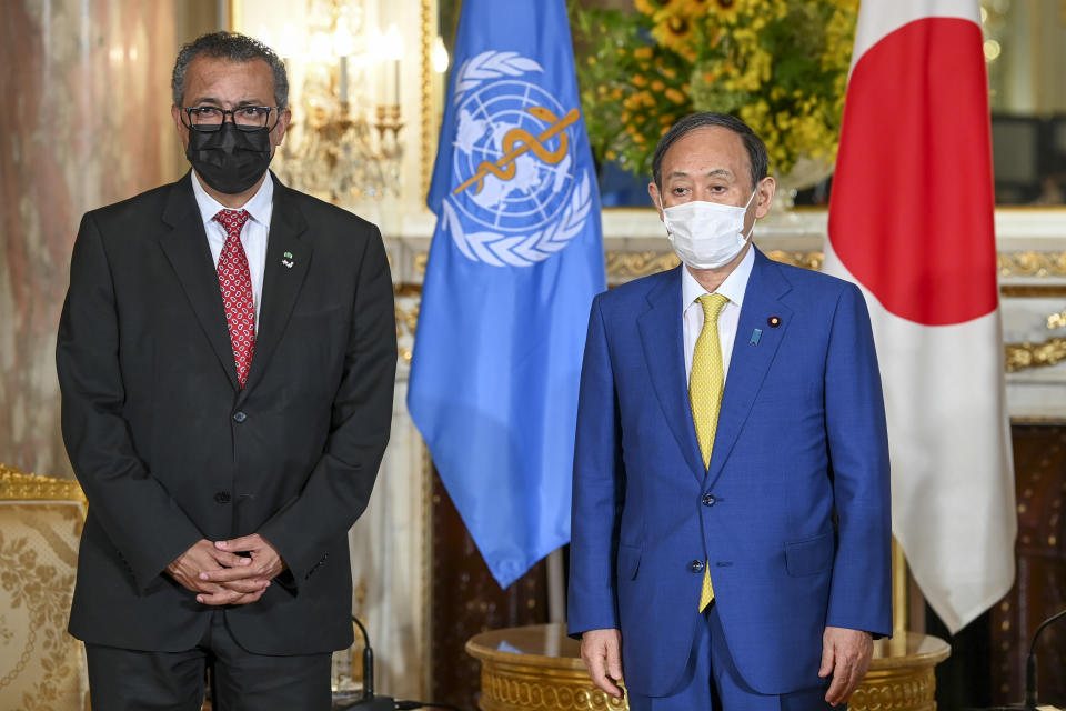 World Health Organization Director-General Tedros Adhanom Ghebreyesus, left, and Japanese Prime Minister Yoshihide Suga wearing face masks pose for a photo at the Akasaka State Guest House in Tokyo Thursday, July 22, 2021. (Kazuhiro Nogi/Pool Photo via AP)