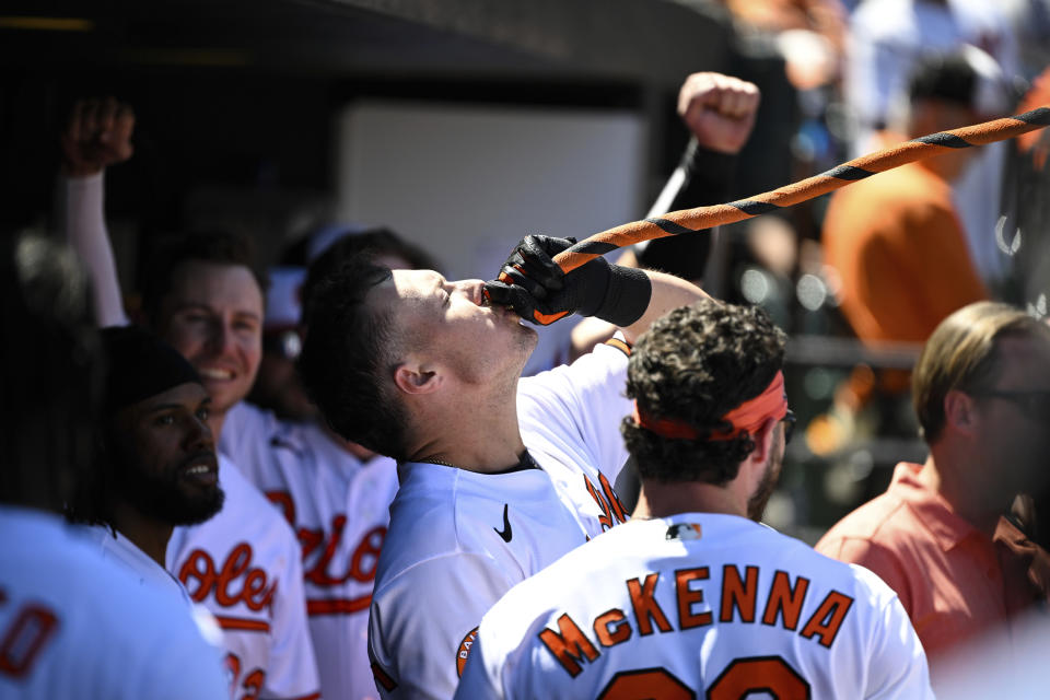Baltimore Orioles' Ryan Mountcastle, center, drinks from a funnel in the dugout after hitting a solo home run against Oakland Athletics starting pitcher Adam Oller during the third inning of a baseball game, Thursday, April 13, 2023, in Baltimore. (AP Photo/Terrance Williams)