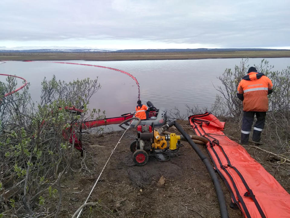 Workers attempt to prevent the spread of the spill. (Photo: Russian Marine Rescue Service via AP)