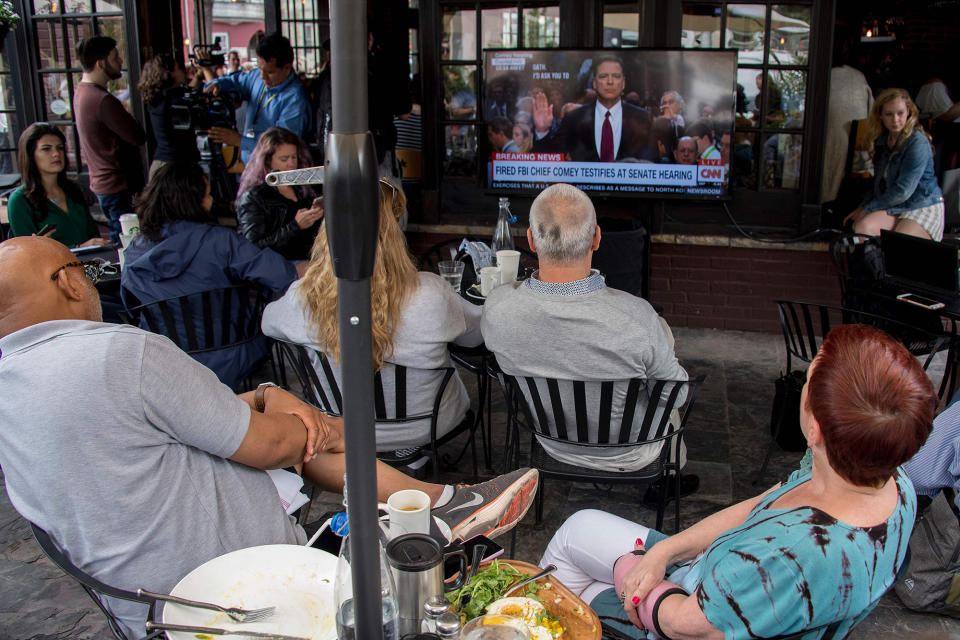 <p>Spectators and patrons at Shaw’s Tavern in northwest Washington watch as former FBI Director James Comey is sworn in to testify before the Senate Intelligence Committee on June 8, 2017. (Photo: Jim Watson/AFP/Getty Images) </p>