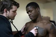 Theon Davis, 21, who fights at the 176-pound weight class, is examined by an official doctor on a night of quarter-final boxing matches at the Chicago Golden Gloves tournament Thursday, March 16, 2023, at Cicero Stadium in Cicero, Ill. Davis trains out of Garfield Park Boxing Gym in Chicago. (AP Photo/Erin Hooley)