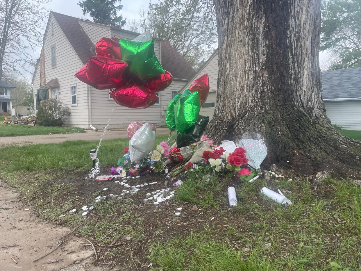 Balloons, candles and other items sit at the base of a tree Monday, April 29, 2024, near the scene of a crash that killed two juveniles and injured five more Saturday, April 27, 2024.