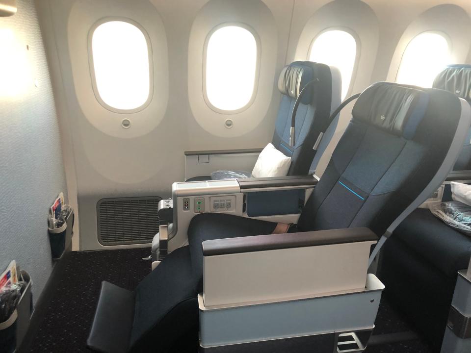 A KLM Premium Comfort seat reclined with the leg and foot rests extended