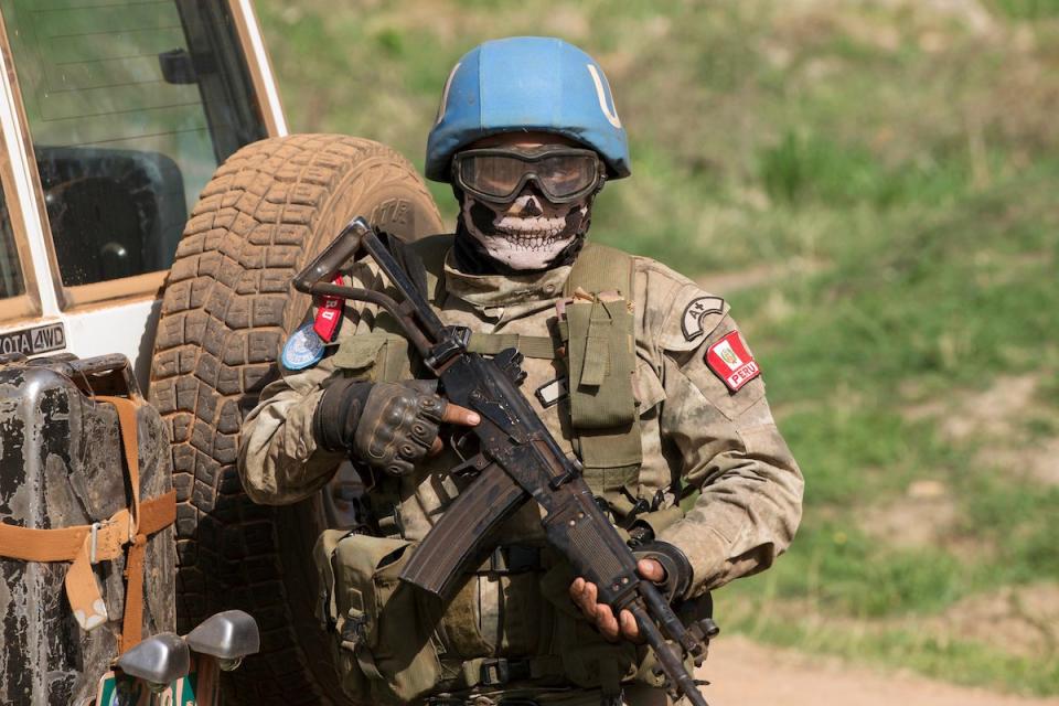 A United Nations peacekeeping soldier provides security during a food aid delivery by the United Nations Office for the Coordination of Humanitarian Affairs and world food program in the village of Makunzi Wali, Central African Republic, April 27, 2017.