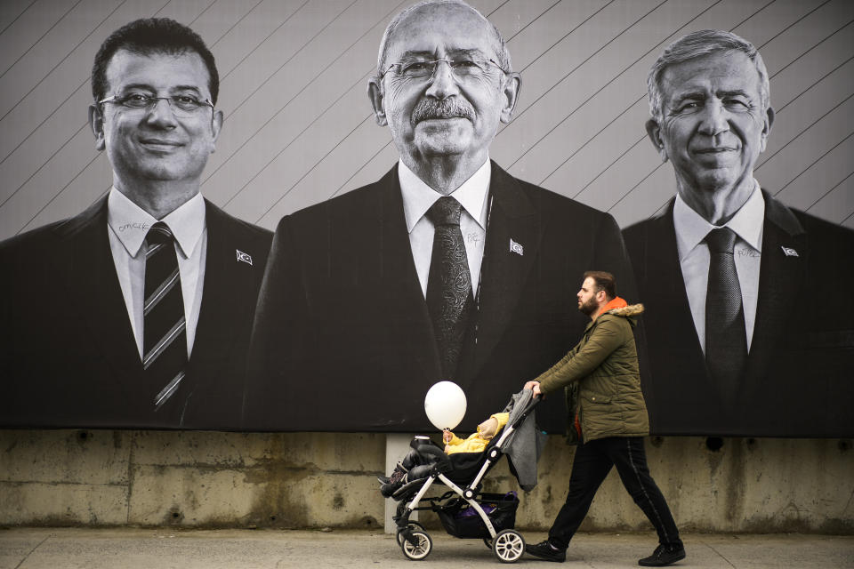 A man walks past a billboard of Turkish CHP party leader and Nation Alliance's presidential candidate Kemal Kilicdaroglu, centre, Istanbul Mayor Ekrem Imamoglu, left, and Ankara Mayor Mansur Yavas, in Istanbul, Saturday, May 6, 2023. Two opposing visions for Turkey’s future are on the ballot when voters return to the polls Sunday for a runoff presidential election, which will decide between an increasingly authoritarian incumbent President Recep Tayyip Erdogan and challenger Kemal Kilicdaroglu, who has pledged to restore democracy. (AP Photo/Emrah Gurel)