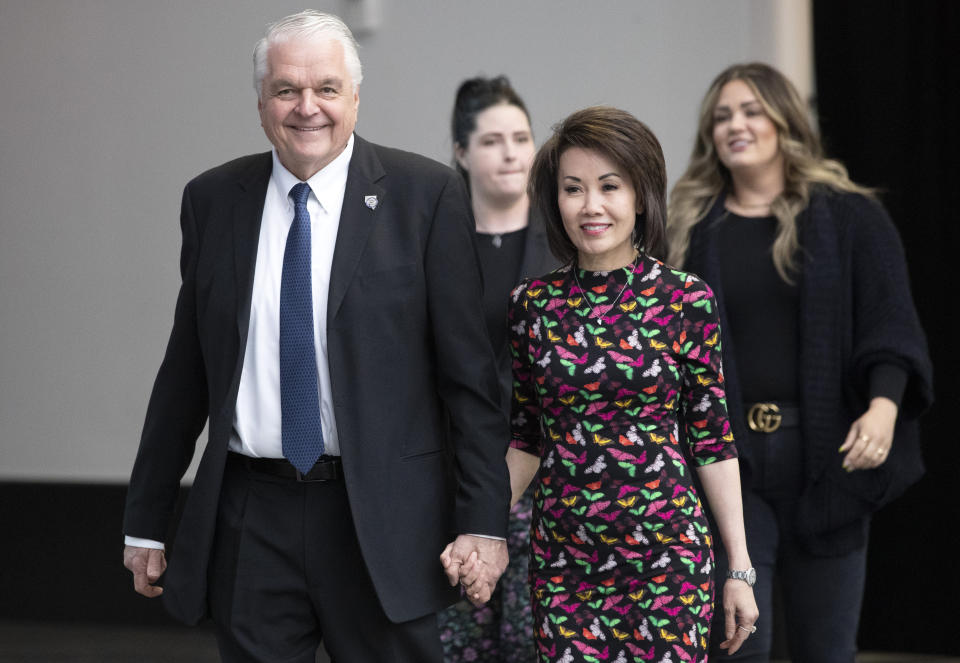 FILE - Nevada Gov. Steve Sisolak arrives with his wife Kathy to deliver his State of the State address at Allegiant Stadium in Las Vegas, Wednesday, Feb. 23, 2022. In the background are the governor's daughters Ashley Sisolak, left, and Carley Sisolak. The governor and his wife were accosted during the weekend by two men who followed them out of a Las Vegas restaurant shouting profanities, taunts and anti-government statements in an incident posted on the internet. (Steve Marcus/Las Vegas Sun via AP, File)