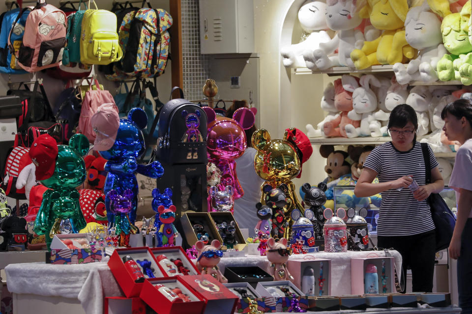 Women shop at the Shanghai Disney flagship store at the Hongqiao Railway Station in Shanghai, China, Monday, Oct. 14, 2019. China's trade with the United States fell by double digits again in September amid a tariff war that threatens to tip the global economy into recession. (AP Photo/Andy Wong)