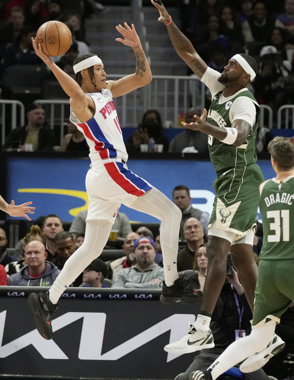 Detroit Pistons guard R.J. Hampton (14) looks to pass as Milwaukee Bucks forward Bobby Portis (9) defends during the first half of an NBA basketball game, Monday, March 27, 2023, in Detroit. (AP Photo/Carlos Osorio)