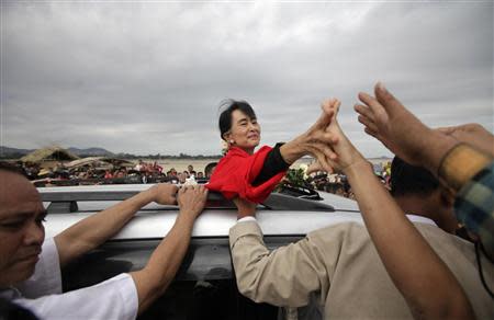 Myanmar's pro-democracy leader Aung San Suu Kyi shakes hands with supporters after giving a speech in Monywa in this November 30, 2012 file photo. REUTERS/Soe Zeya Tun/Files