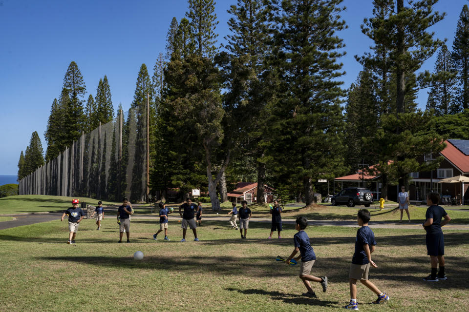 Sacred Hearts School third grade students during recess at a golf course at Kapalua Resort on Tuesday, Oct. 3, 2023, in Lahaina, Hawaii. The three public schools that survived the deadly August wildfire are set to reopen this week. (AP Photo/Mengshin Lin)