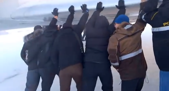 Plane passengers get out and push after landing gear freezes