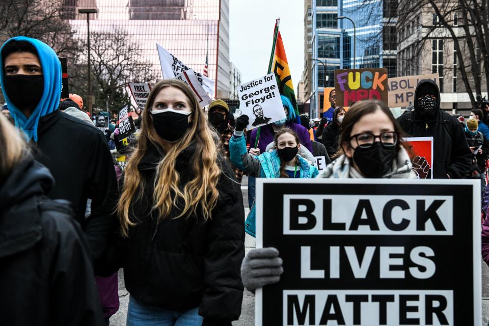 People hold placards as they protest outside of the Courthouse during the trial of former Minneapolis police officer charged with murdering George Floyd in Minneapolis, Minnesota on April 19, 2021.(Chandan Khanna/AFP via Getty Images)