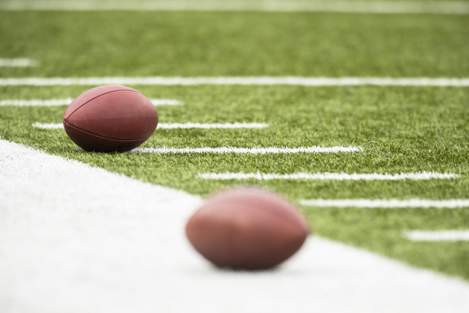 American footballs rest on the sideline before the game between the Buffalo Bills and the Jacksonville Jaguars.